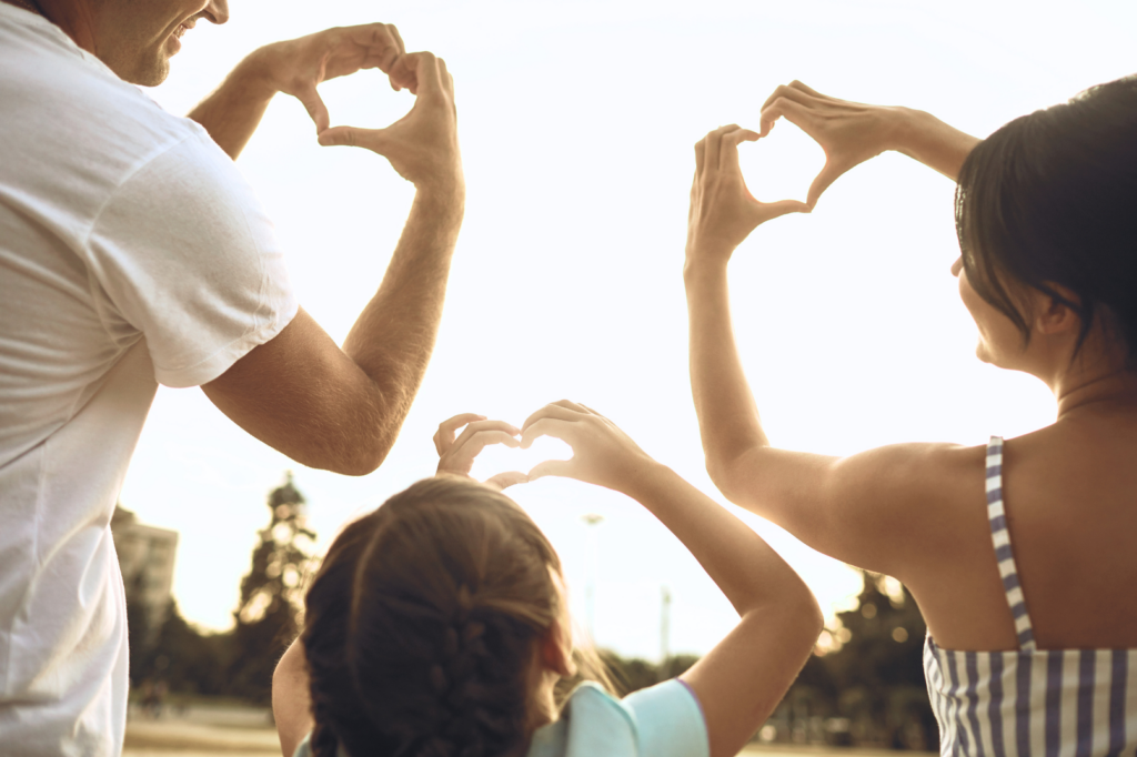 Family making hearts with hands after finding insurance resources from The World Changers